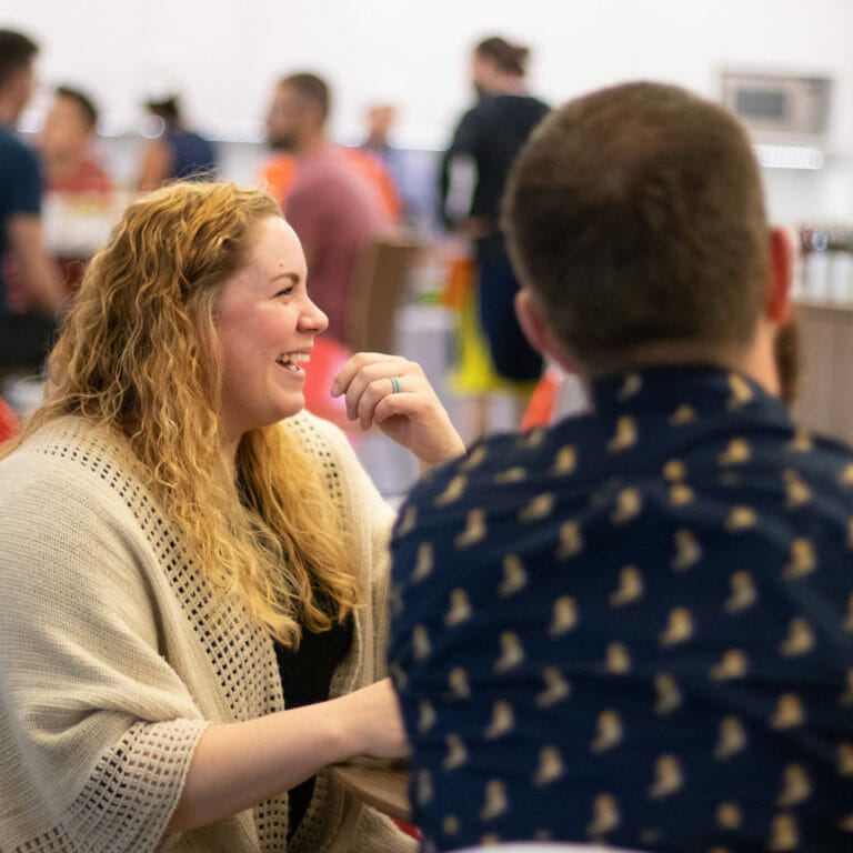 Two engaged employees laughing