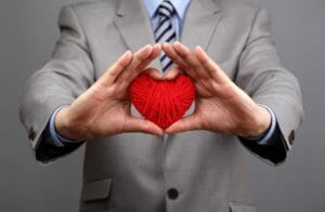 Man holding ball of yarn in the shape of a heart