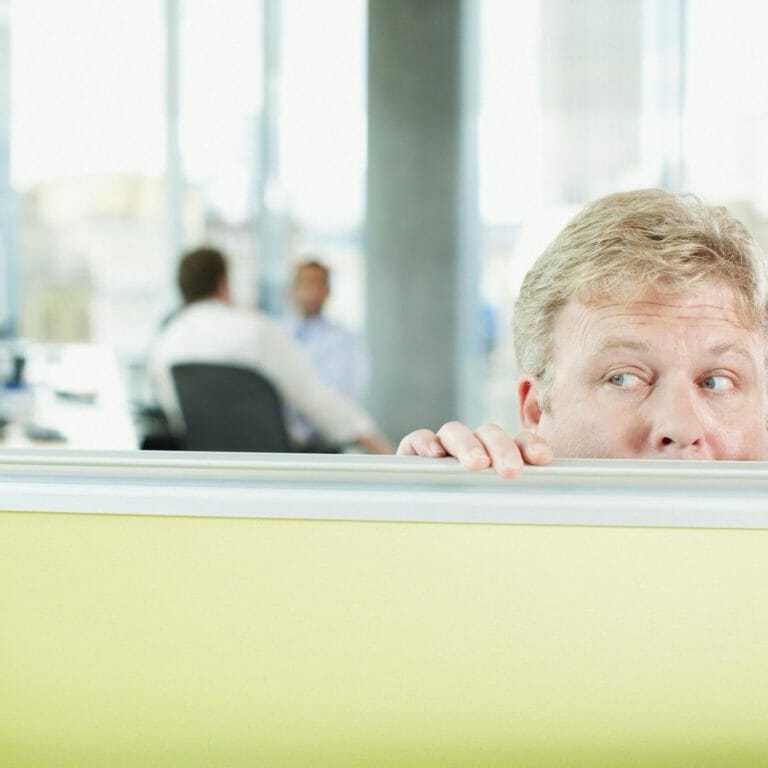 Man peering over desk