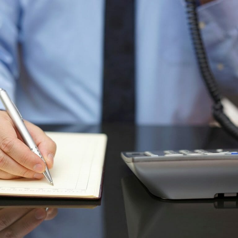 Man on phone taking notes