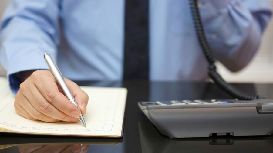 Man on phone taking notes