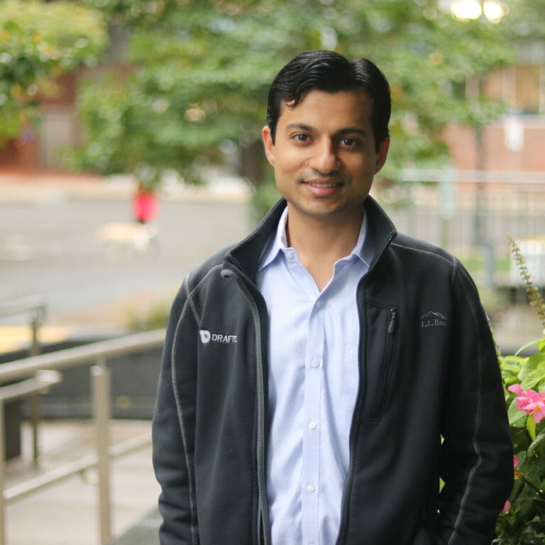 diverse employee stands outside workplace