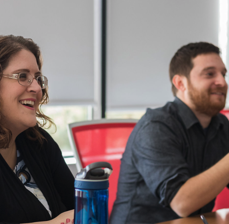 Two coworkers laughing in meeting